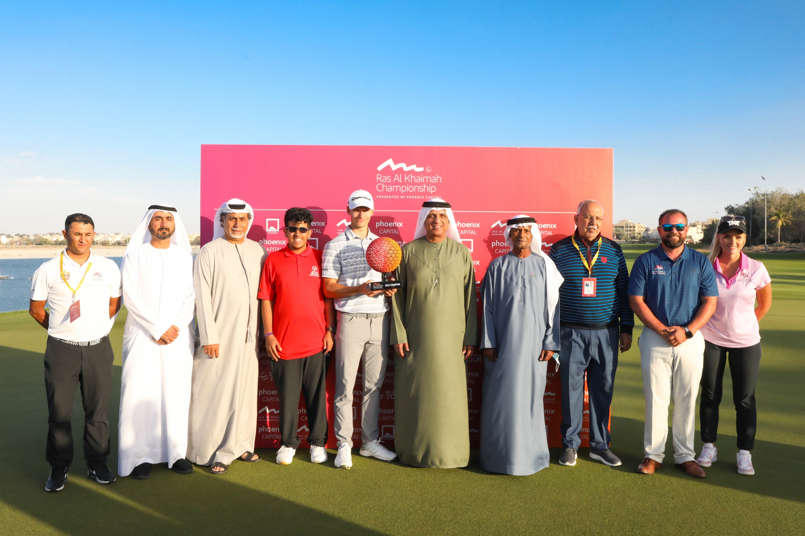 Ruler of ras al khaimah and guests awarding golf champion the award